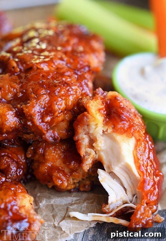 Close-up of a stack of Honey BBQ Chicken Strips, highlighting their juicy interior and thick, flavorful glaze.