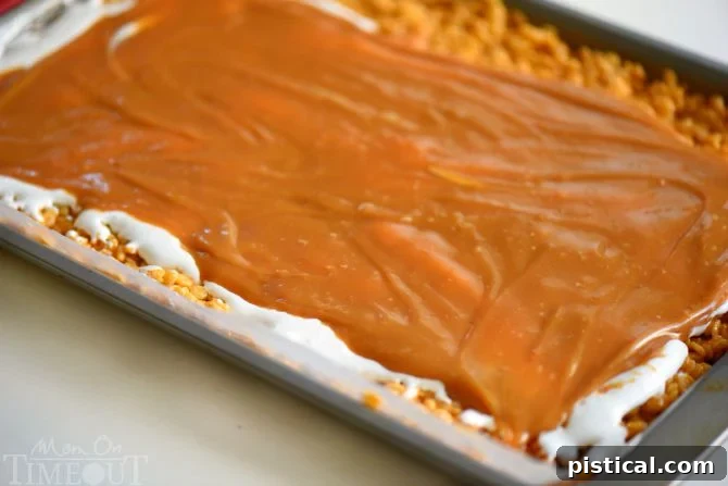 Preparing the rolled Caramel Pumpkin Spice Rice Krispies Treats Pinwheels before slicing, showcasing the vibrant layers and inviting texture.