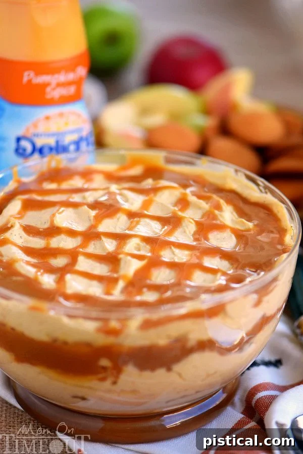 Close-up of Caramel Pumpkin Cheesecake Dip in a bowl, showing the creamy texture and generous caramel drizzle