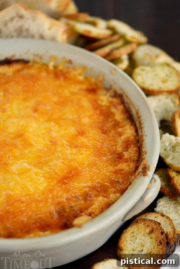 Fire-Roasted Red Pepper Shrimp Scampi Dip 4 A bowl of creamy Roasted Red Pepper Shrimp Scampi Dip, garnished with fresh parsley and served with various dippers.
