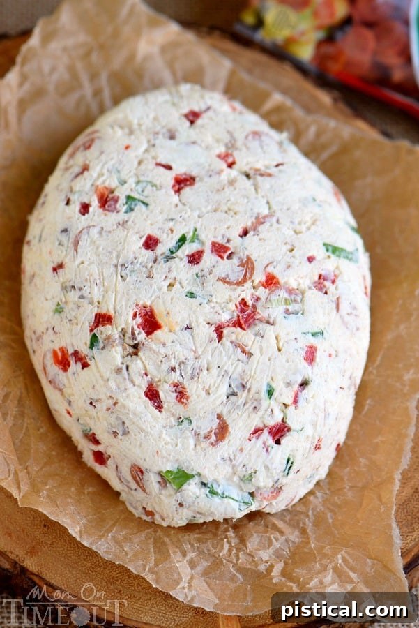 A close-up shot of the football-shaped cheese ball covered in mini pepperoni, ready for game day fun.