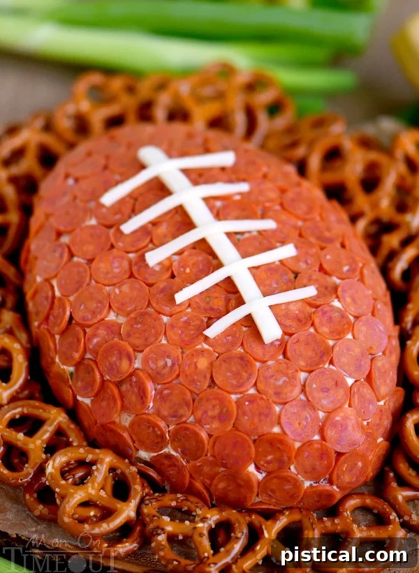 The finished Pepperoni Pizza Football Cheese Ball, adorned with mozzarella laces, ready to be served.