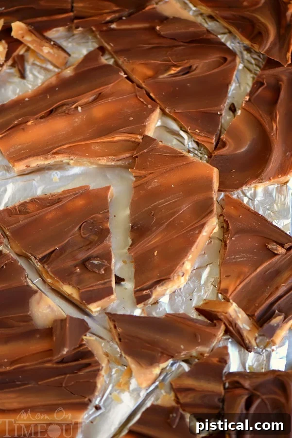 Broken pieces of golden butterscotch almond toffee scattered, highlighting the crunchy texture and almond bits