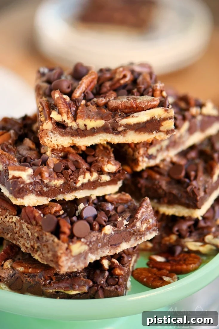 Stacked chocolate pecan pie bars displaying their multiple delicious, rich layers, perfectly arranged and ready to be enjoyed.