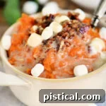 Marshmallow Topped Sweet Potato Bliss 6 Mashed sweet potatoes topped with marshmallows and pecans in a beige bowl