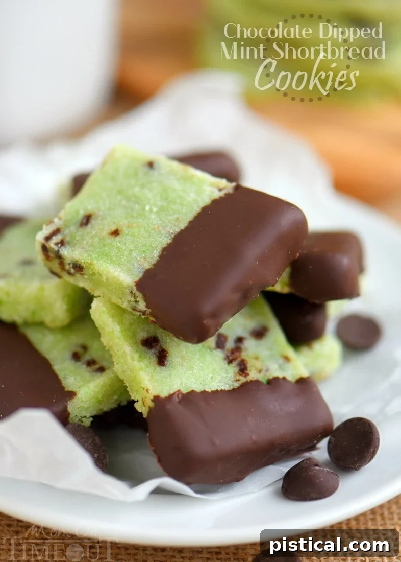 A festive plate of chocolate-dipped mint shortbread cookies, showcasing their rich chocolate coating and delicate mint green interior.