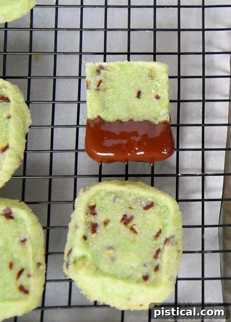 Close-up of a perfectly dipped chocolate mint shortbread cookie, showcasing its elegant shape and rich glaze.