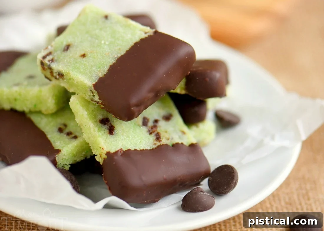 Various chocolate-dipped mint shortbread cookies artfully arranged on a white serving tray, ready for holiday enjoyment.