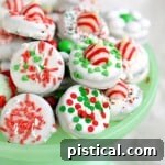 Your Essential Guide to Holiday Peppermint Oreos 3 Festive dipped Oreo cookies decorated for Christmas, displayed on a green cake stand.