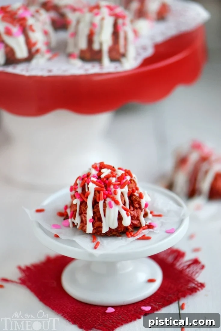 Close-up of a beautifully drizzled Red Velvet Coconut Macaroon with festive sprinkles.