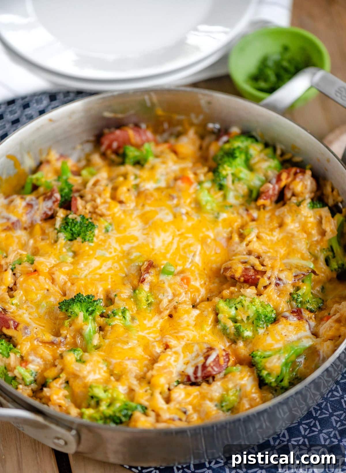 Hearty Cheesy Kielbasa and Broccoli Rice Skillet 6 An angled shot of the Cheesy Kielbasa Rice and Broccoli Skillet, showcasing the perfectly melted, bubbly cheese topping, with glimpses of the kielbasa, rice, and broccoli underneath.