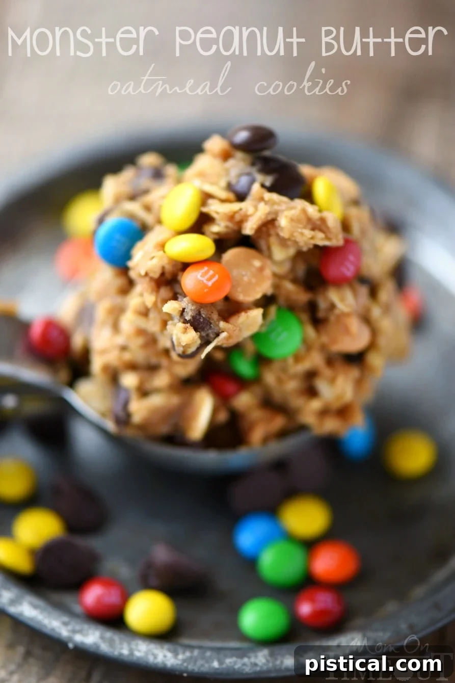 A generous stack of Monster Peanut Butter Oatmeal Cookies, bursting with chocolate chips and M&M's, perfect for a sweet craving.