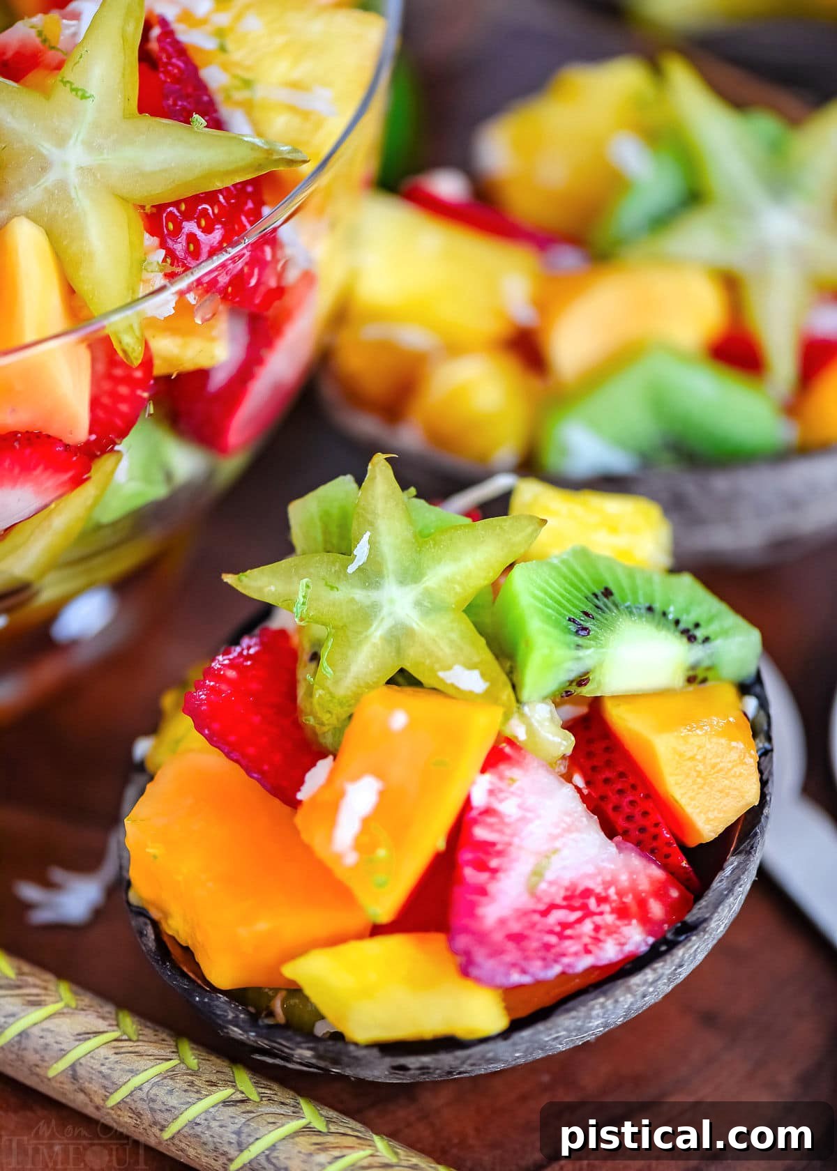 Island Fruit Medley with Zesty Honey Glaze 3 coconut half filled with tropical fruit salad. very brightly colored fruits.