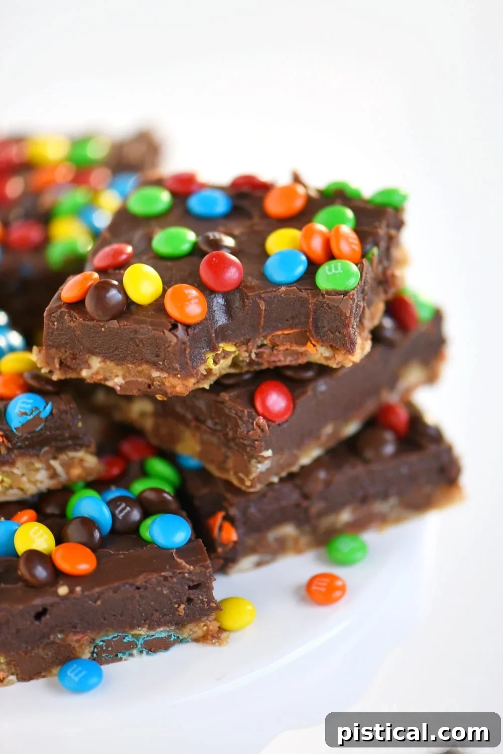 Close-up of Monster Fudge Bars with a thick layer of fudge and M&M's on top of a cookie base.