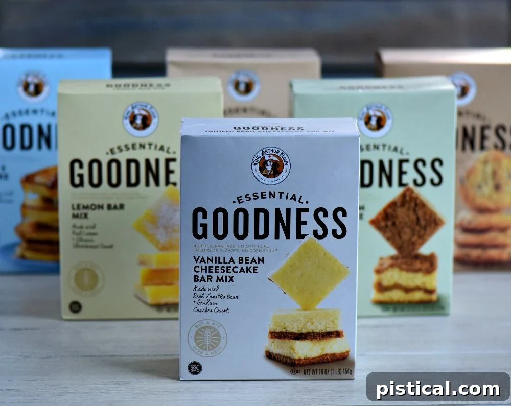 Assortment of King Arthur Flour Essential Goodness mixes, including Sour Cream Coffee Cake, Lemon Bars, Chocolate Chip Cookies, and Vanilla Bean Cheesecake Bars, showcasing the diverse range of baking options.