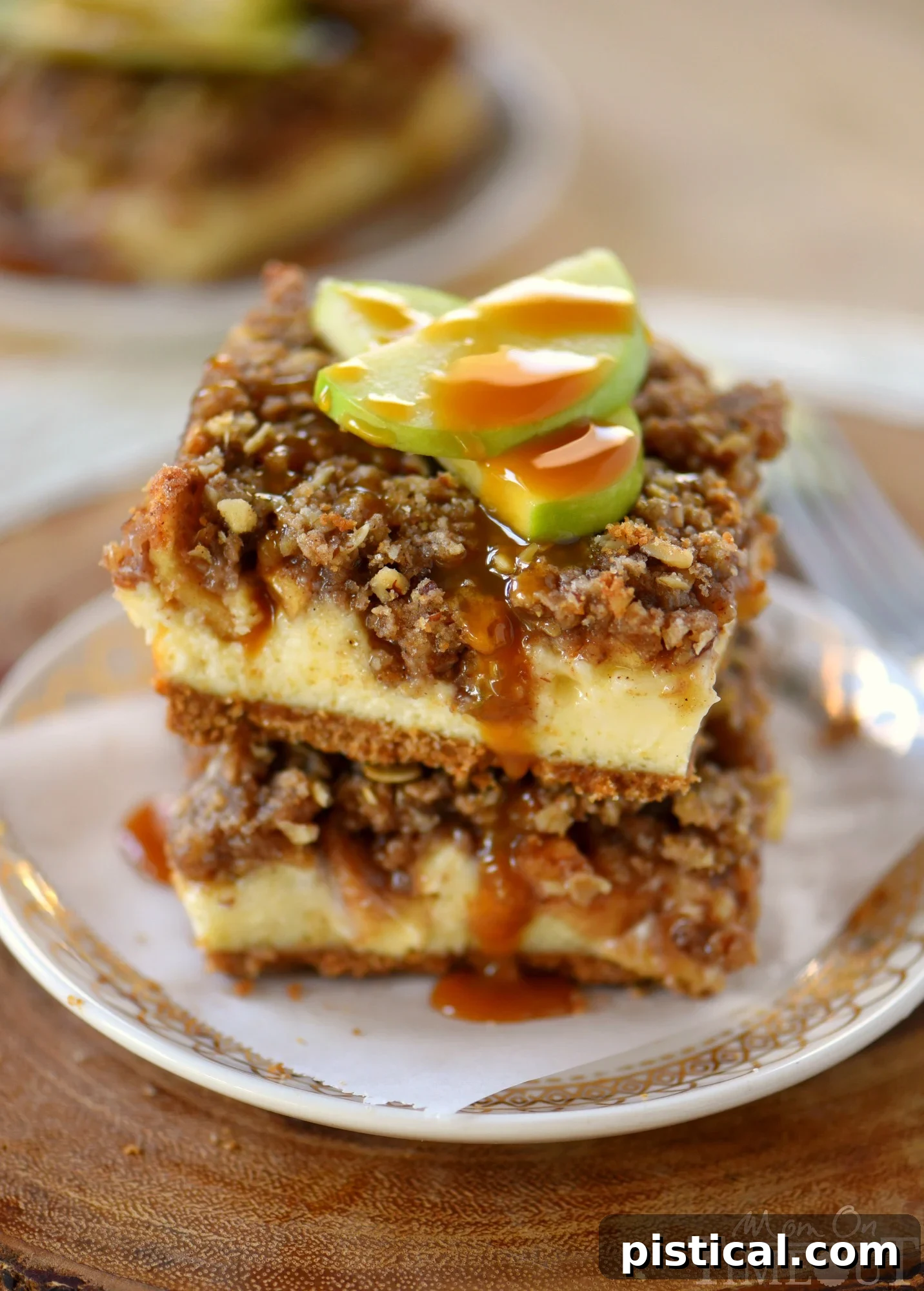 Another beautiful shot of Dutch Apple Pie Cheesecake Bars, emphasizing their layered texture and inviting appeal, topped with optional caramel drizzle, perfect for autumn celebrations.