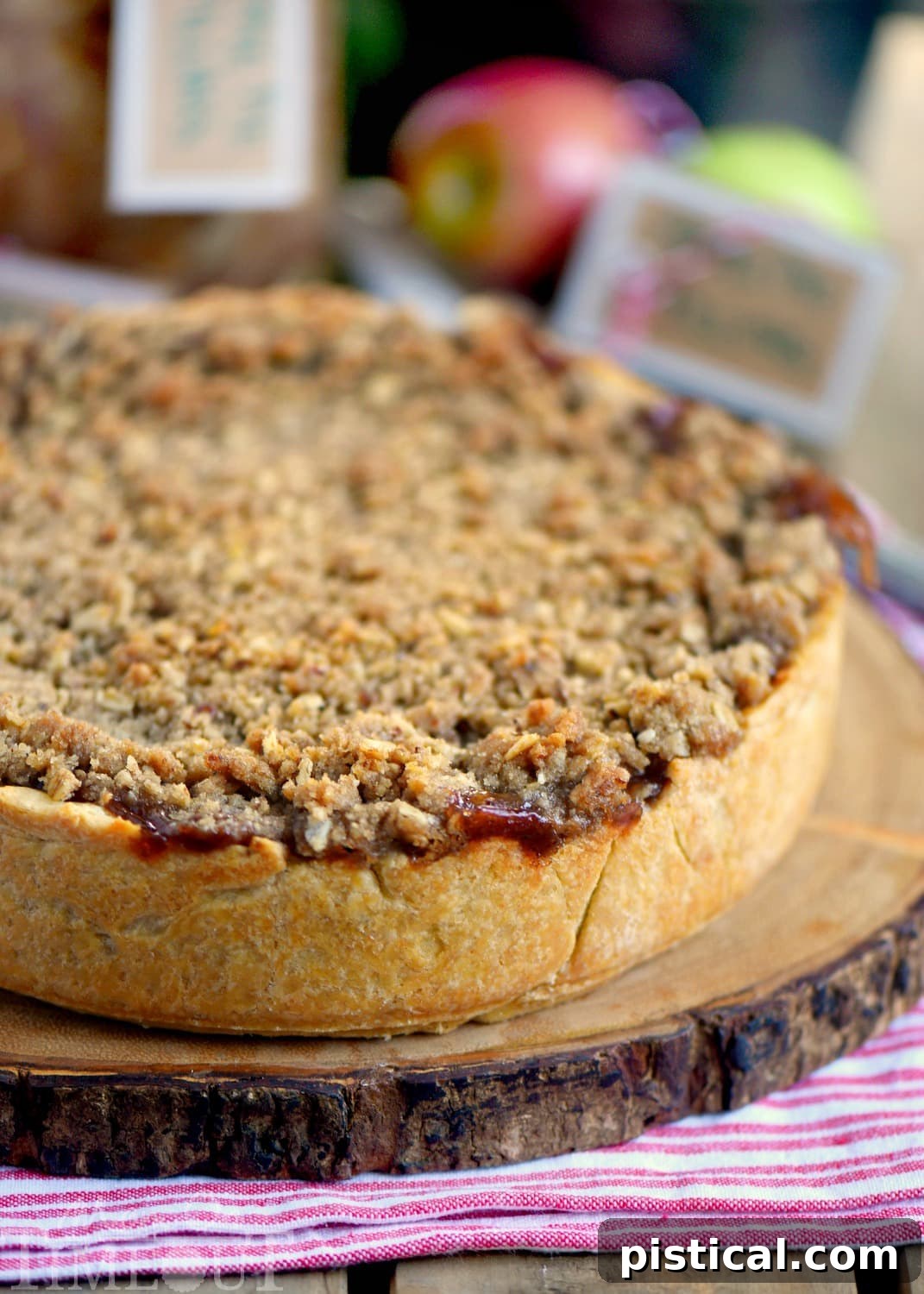 A perfectly baked Deep Dish Dutch Apple Pie, showcasing its golden pecan streusel topping and thick apple filling, ready to be served with vanilla ice cream and caramel sauce.