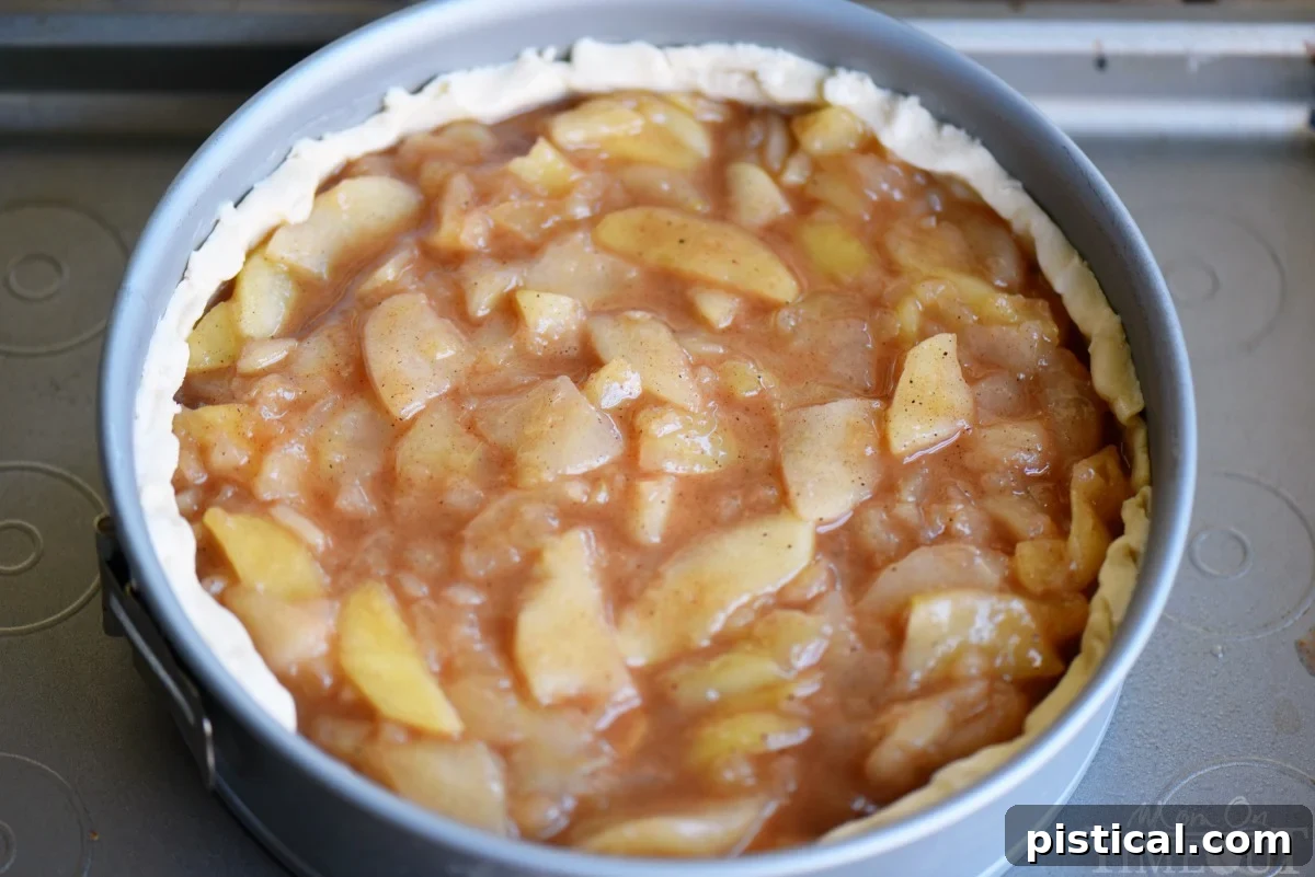 Close-up of the rich, spiced apple pie filling, ready to be topped with streusel in a deep-dish apple pie.