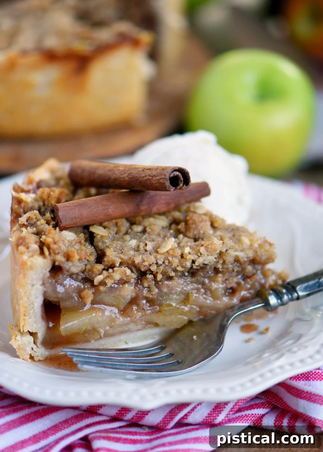 A slice of Deep Dish Dutch Apple Pie served with a scoop of vanilla ice cream and a generous drizzle of caramel sauce, highlighting its appeal as a festive fall dessert.