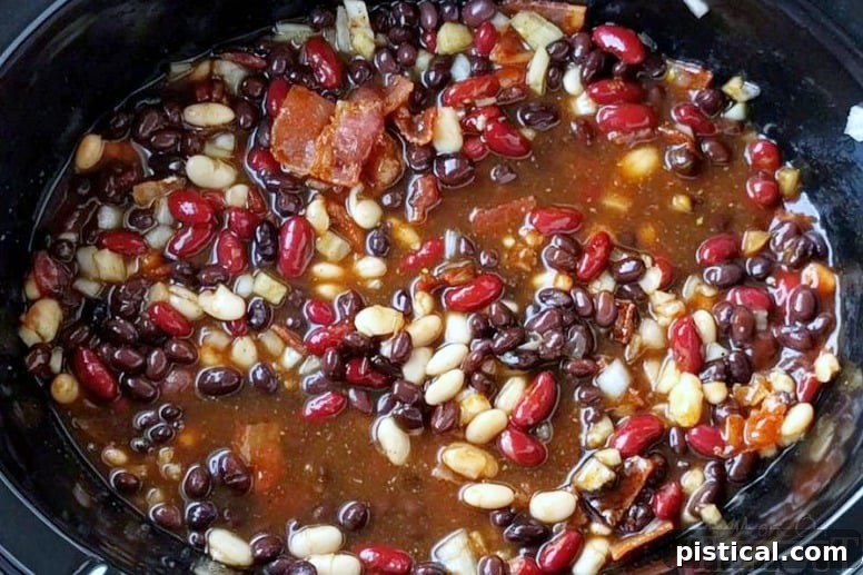 Slow Cooker Kielbasa and Barbecue Beans all mixed together in crockpot, showcasing the rich blend of ingredients.