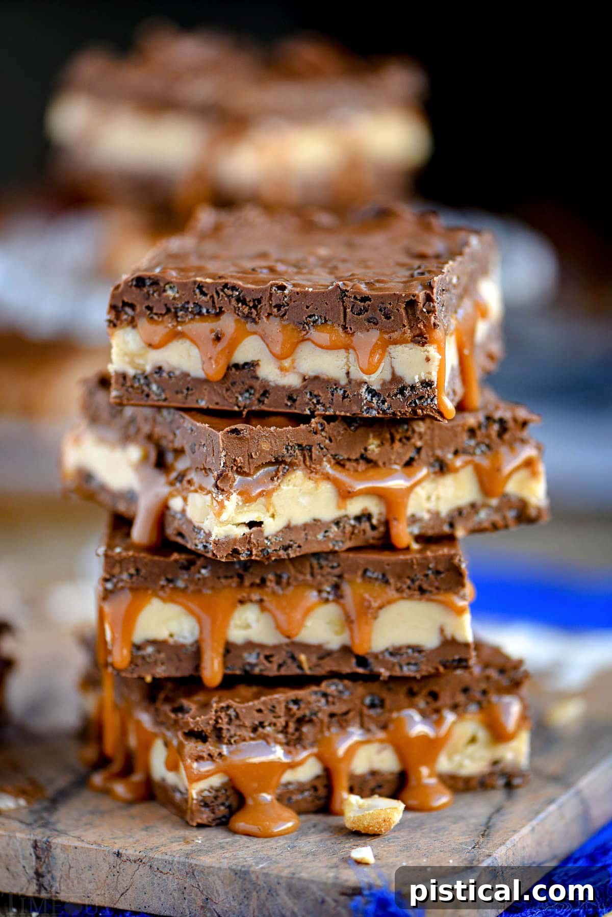 Four stacks of caramel nougat Snickers bars, showcasing their irresistible layers and texture.