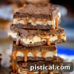 caramel nougat snickers bars stacked on each other, four high.