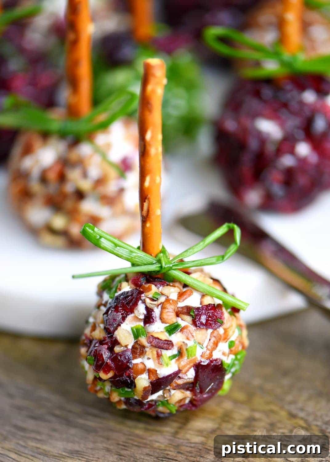 Sweet and Tangy Cranberry Pecan Goat Cheese Truffles 3 Close-up of Cranberry Pecan Mini Goat Cheese Balls on a platter, showcasing the festive coatings of chives, cranberries, and pecans. Ideal for holiday entertaining.