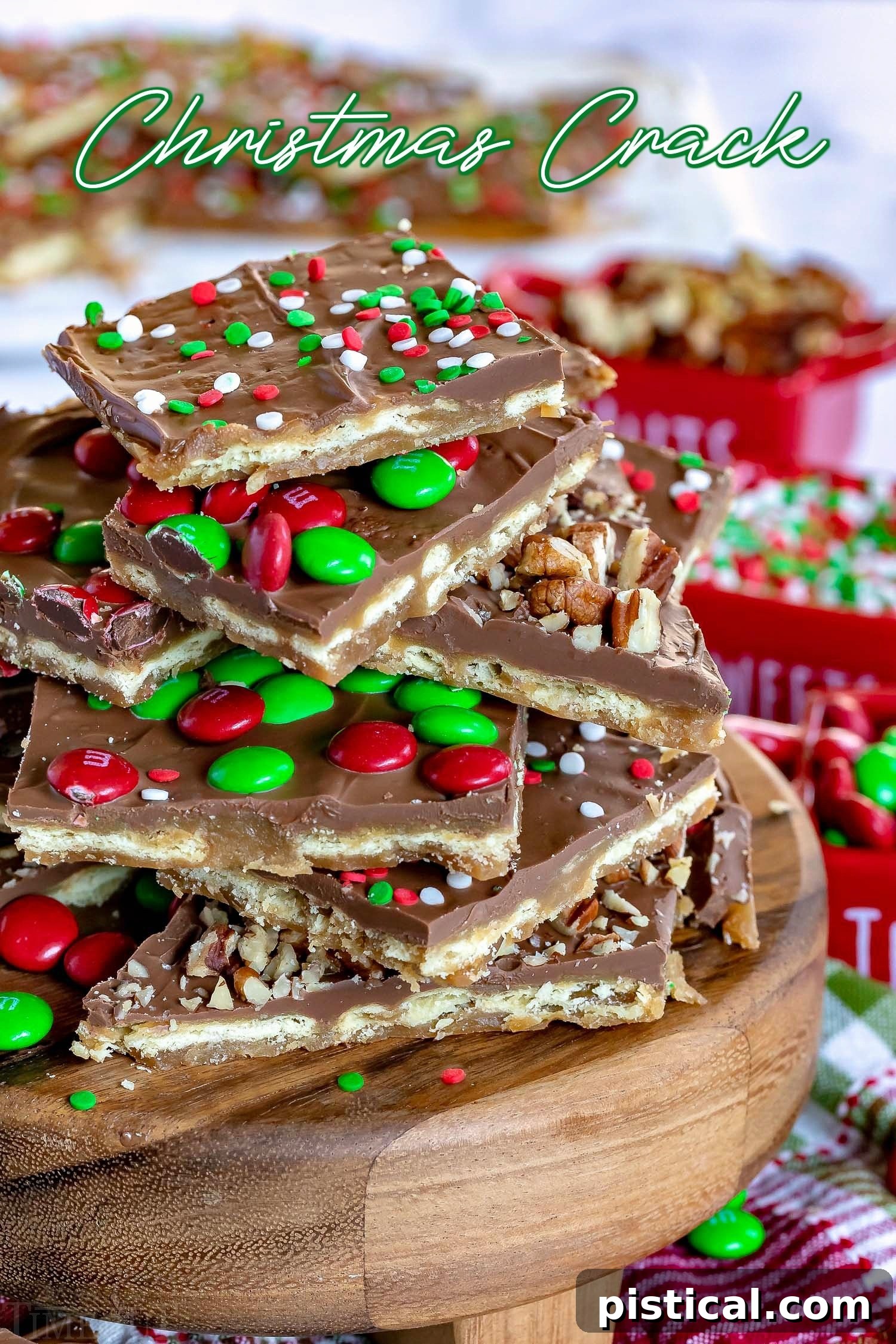 Christmas Crack, a saltine toffee recipe, piled high on a wooden stand with colorful M&M's, sprinkles, and nuts.