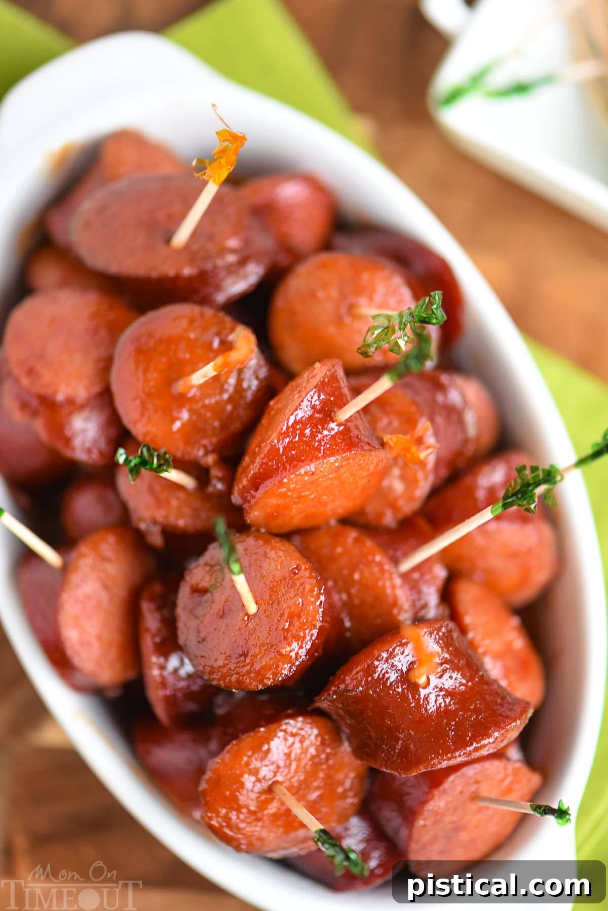 Top down look at white slow cooker full of kielbasa in a sauce made of chili sauce, bbq sauce and grape jelly.