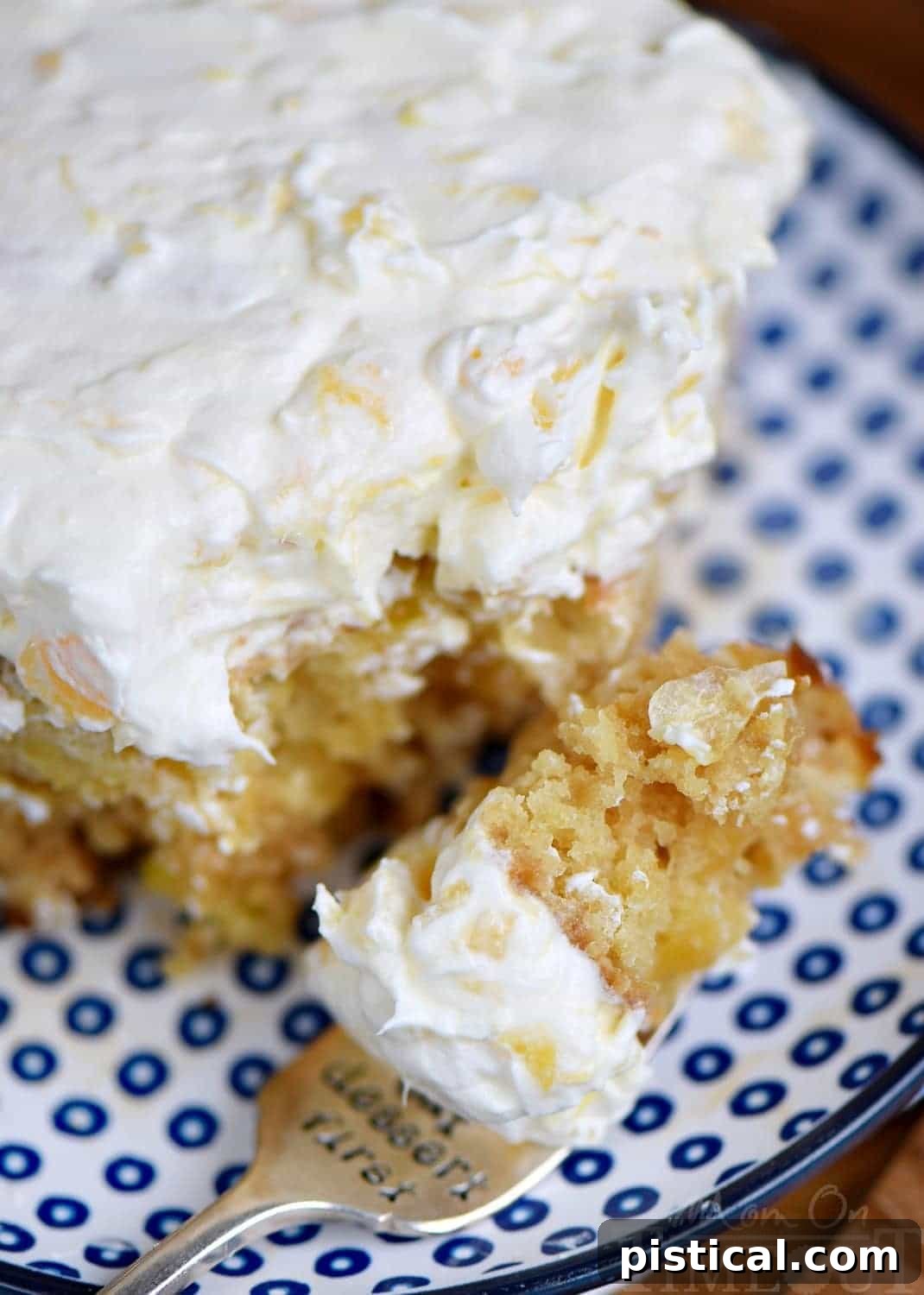 A close-up of a generous serving of pineapple fluff frosting being spread onto the perfectly cooled pineapple cake.