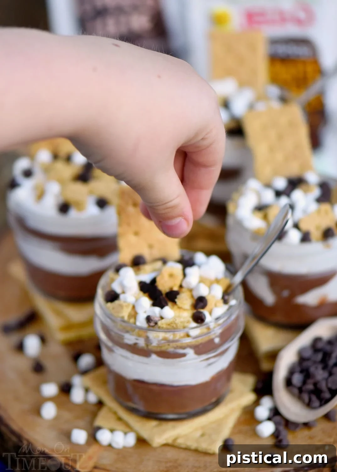 Children's hands eagerly adding toppings to their S'mores Pudding Parfaits, showcasing the customization fun.