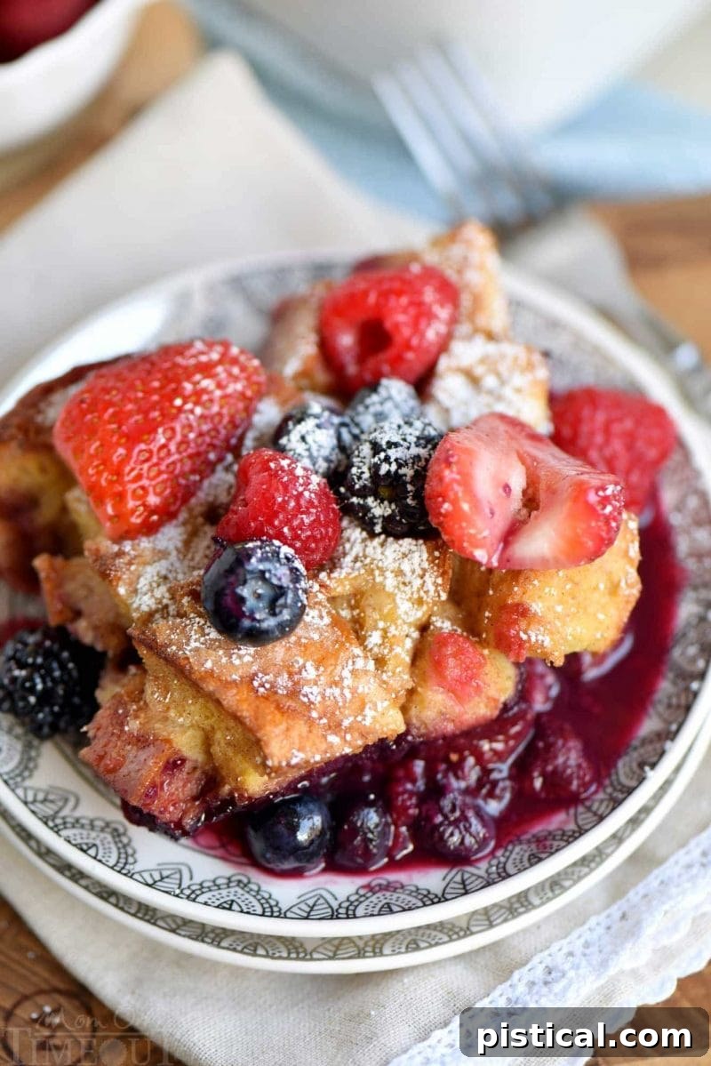 Close-up of a baked Triple Berry French Toast Casserole, showcasing the golden-brown bread and bubbling berry syrup.