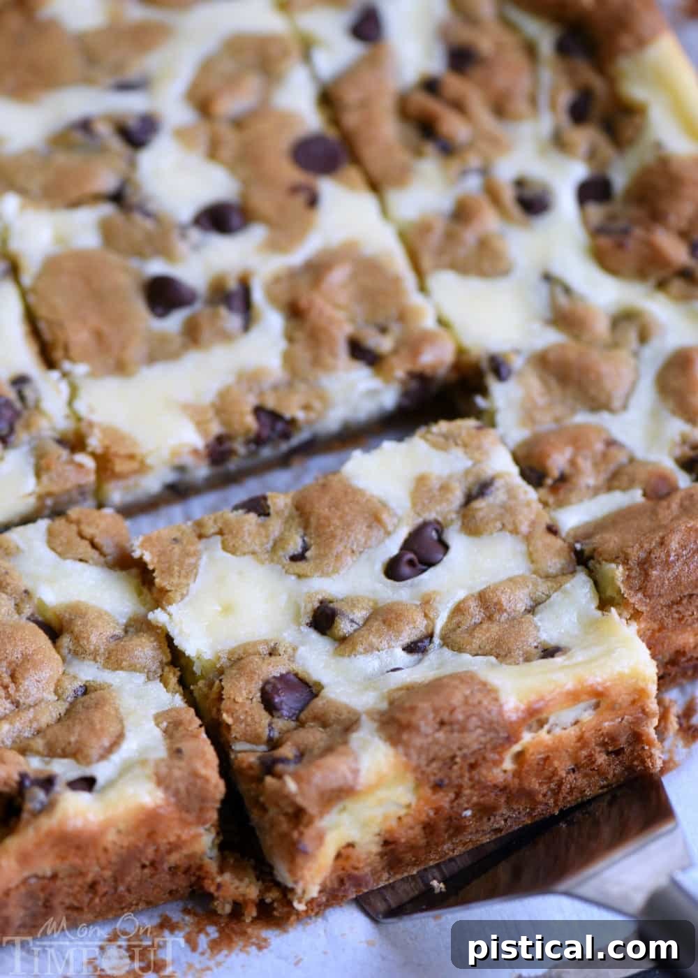 Close-up of a stack of freshly baked Chocolate Chip Cookie Cheesecake Bars, showcasing the golden cookie crust and creamy cheesecake filling.
