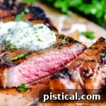 Steak on cutting board with compound butter melting on top.