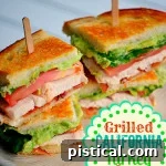 turkey club sandwich with avocado and bacon on small lunch plate