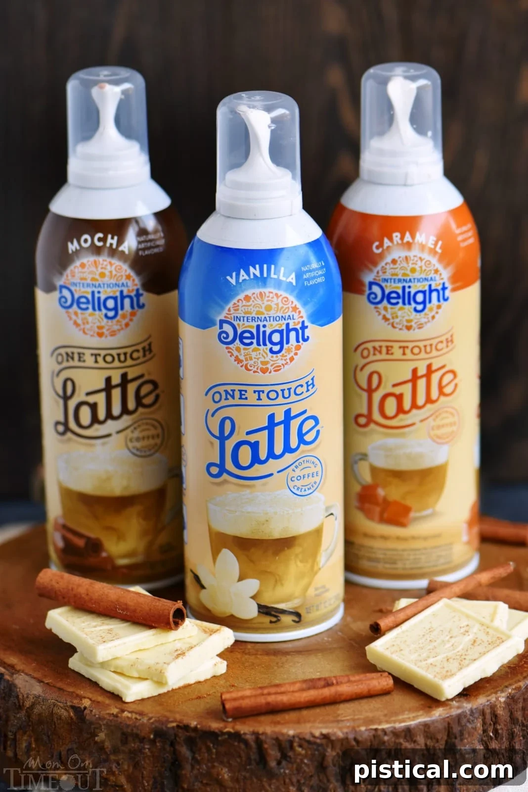 Frosted White Chocolate Snickerdoodle Latte 4 A hand expertly pressing the International Delight One Touch Latte dispenser, demonstrating how effortlessly a rich, frothy topping is created over a mug of coffee. The focus is on the ease and speed of preparing a perfect latte foam at home.