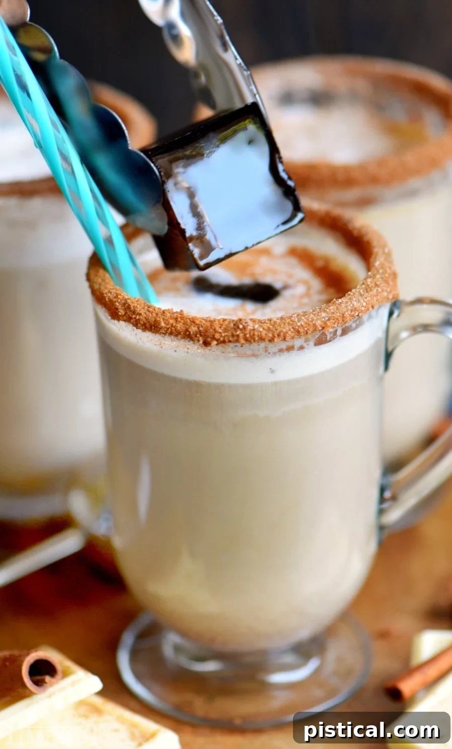 Frosted White Chocolate Snickerdoodle Latte 6 A stylishly presented White Chocolate Snickerdoodle Latte in a tall glass, adorned with a cinnamon stick and a generous swirl of whipped cream. This image beautifully captures the essence of a gourmet, homemade latte experience, emphasizing its rich texture and appealing garnishes, ready to be enjoyed hot or cold.