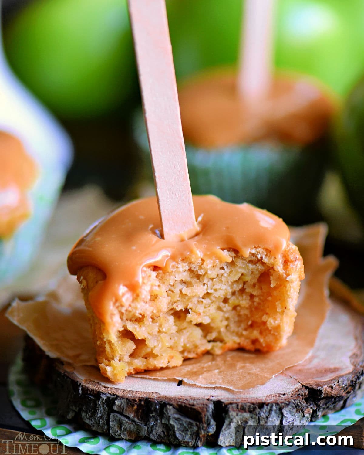 A half-eaten caramel apple cupcake, showing its moist interior and the thick layer of caramel frosting. A small bite reveals the fluffy cake and sweet filling, emphasizing its deliciousness.