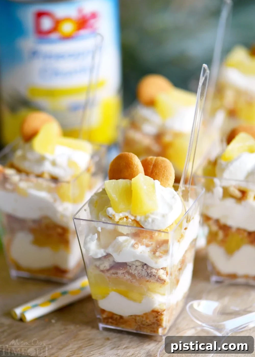A row of Mini Pineapple Cheesecake Trifles, ready for serving, featuring creamy layers and pineapple chunks.