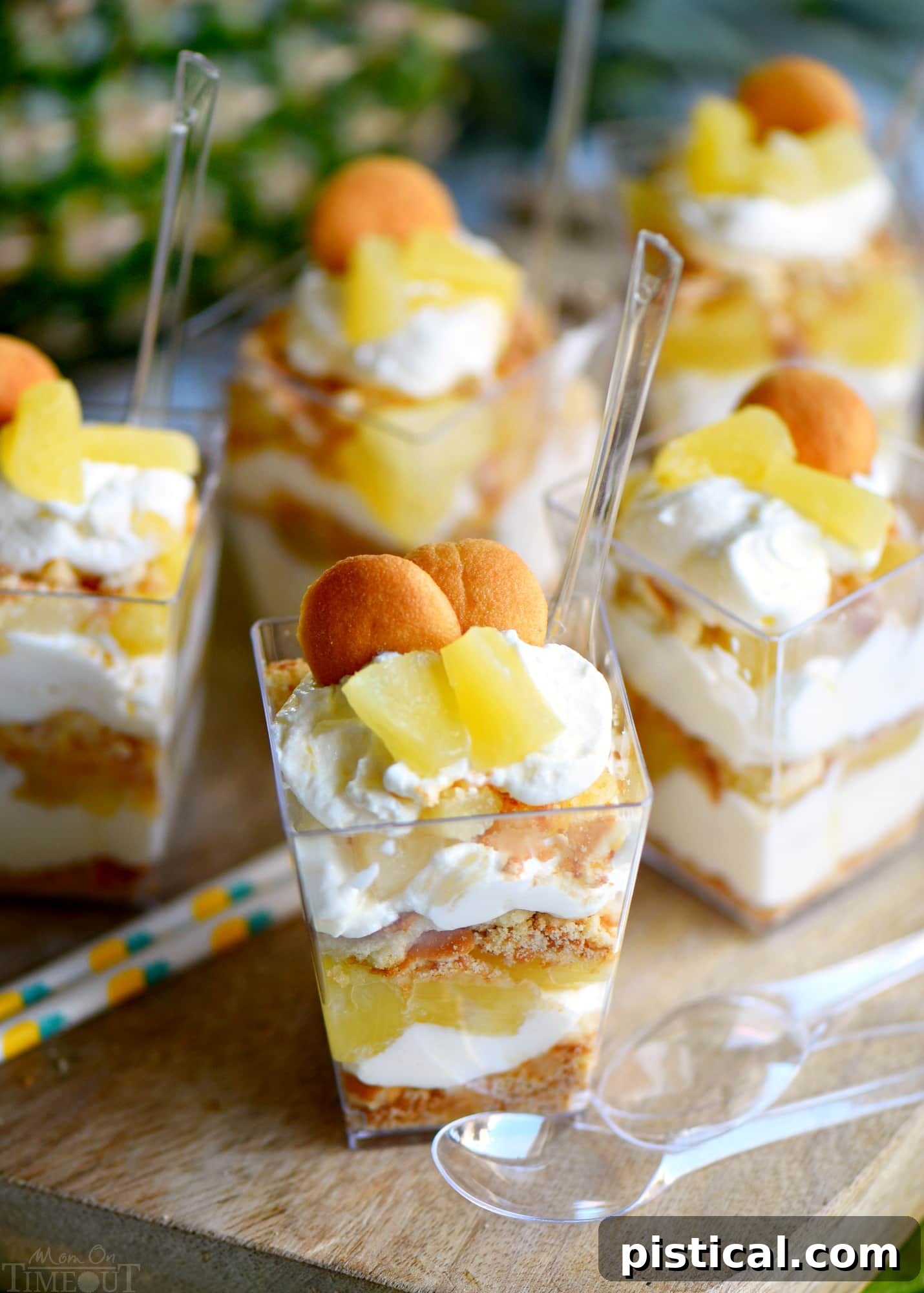 Close up image of an individual Mini Pineapple Cheesecake Trifle, showing distinct layers of wafers, cream cheese filling, and pineapple chunks.