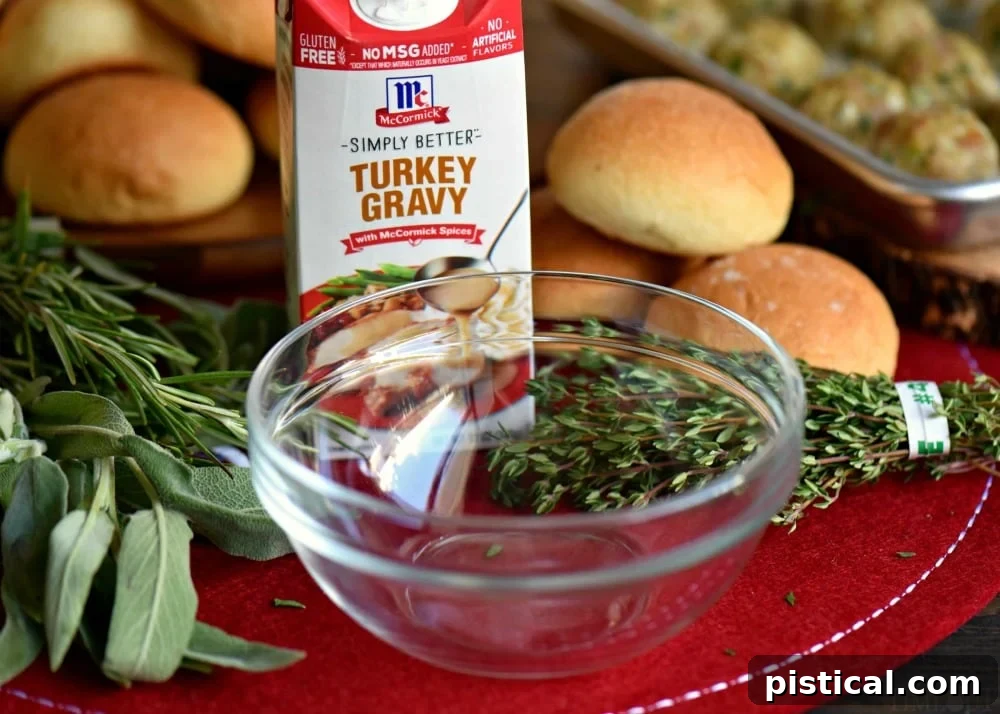 Close-up of baked turkey meatballs generously topped with herbed gravy, ready to eat.
