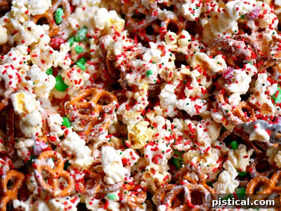 This wonderful holiday Snow Day Snack Mix is the perfect easy treat all winter long! Both sweet and salty, this holiday snack mix is great for Christmas, movie nights, parties, gifts and so much more! A close-up of the finished Snow Day Snack Mix with vibrant M&M's and sprinkles. // Mom On Timeout #christmas #dessert #snack #pretzels #marshmallows #redandgreen #momontimeout