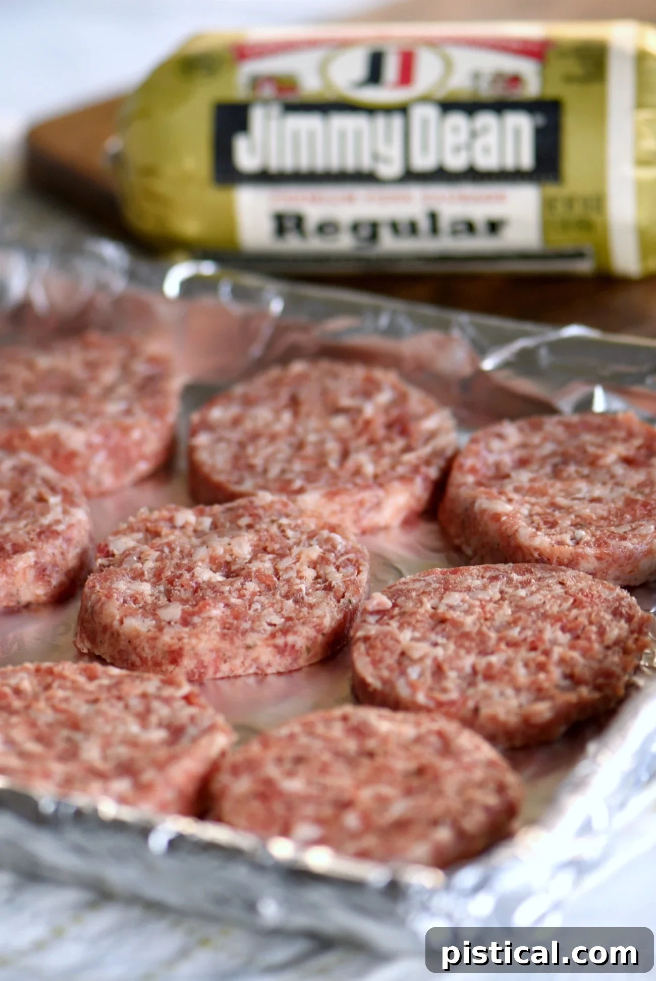 Jimmy Dean Premium Pork Sausage patties baking on a foil-lined sheet pan in the oven, ready for the hash brown cups.