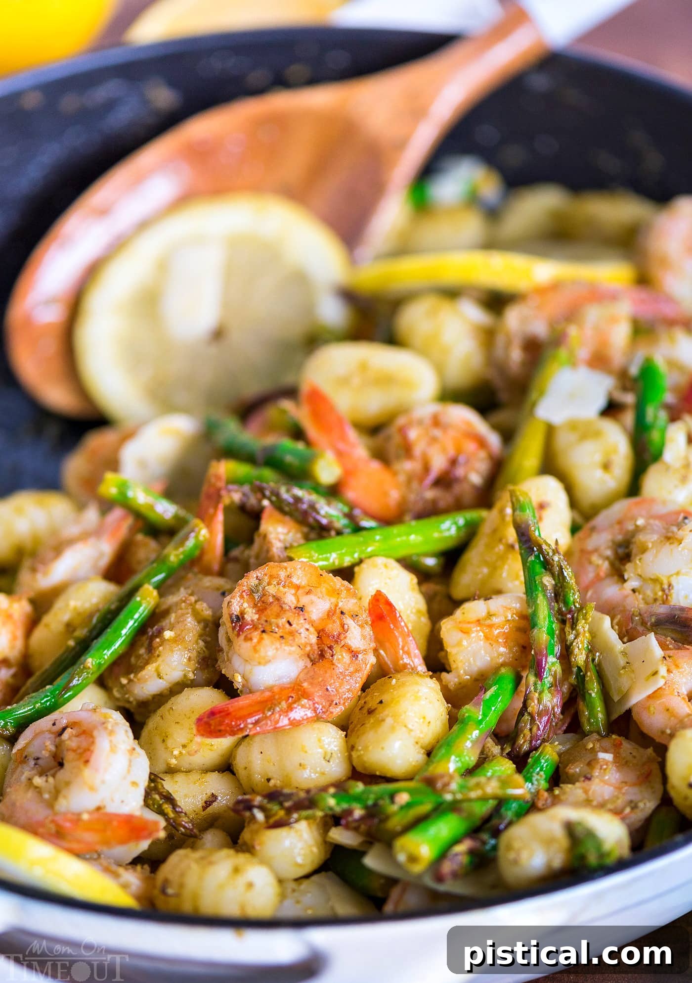 Close-up of perfectly cooked shrimp, gnocchi, and asparagus with pesto.