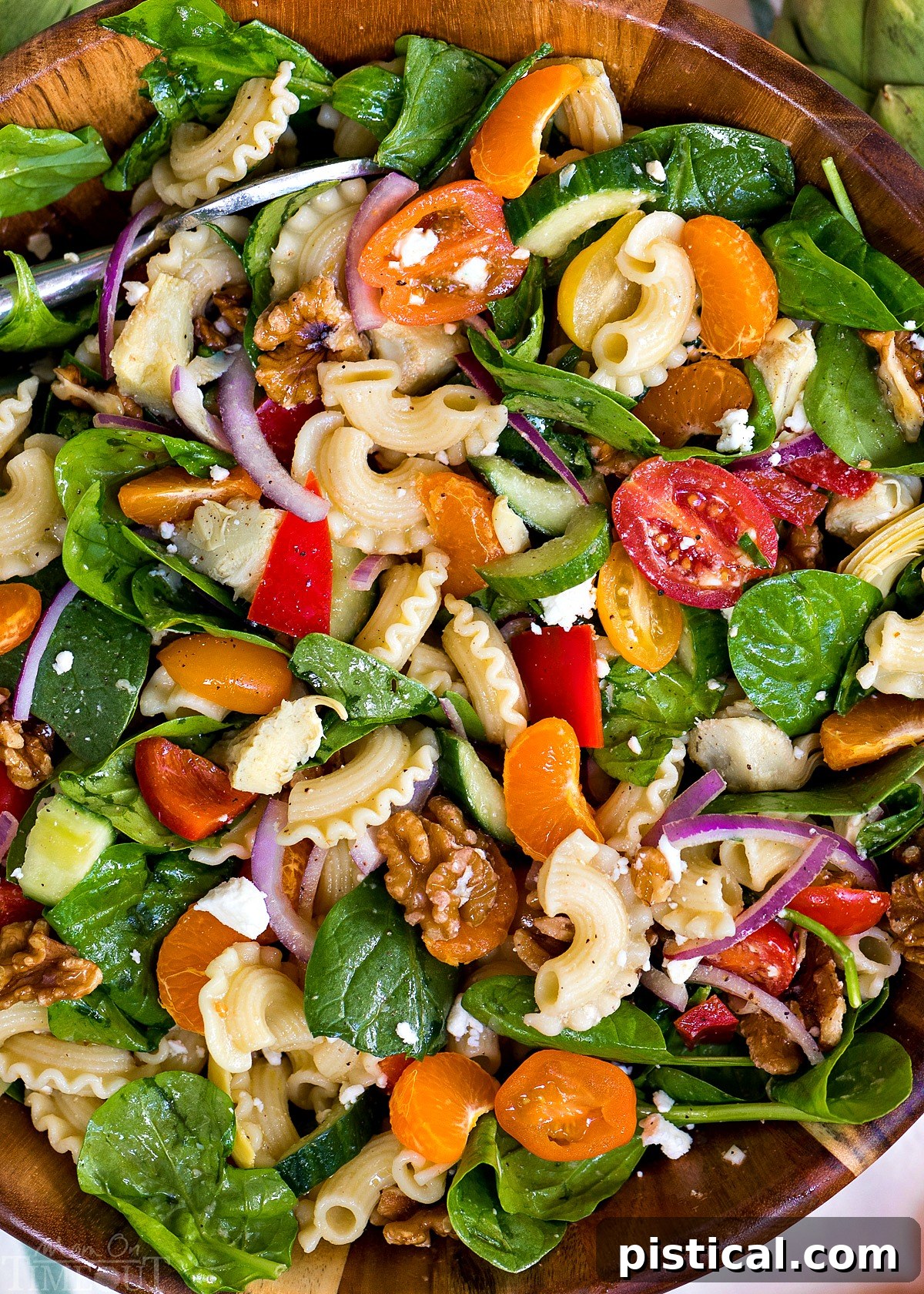 Easy and Flavorful Perfect Pasta Salad Recipe with Artichokes, Spinach, and Mandarins, perfect for any occasion. Close-up of a beautifully composed Perfect Pasta Salad, showcasing the diverse ingredients including pasta, artichoke hearts, vibrant spinach, orange mandarin segments, and crumbled feta cheese.