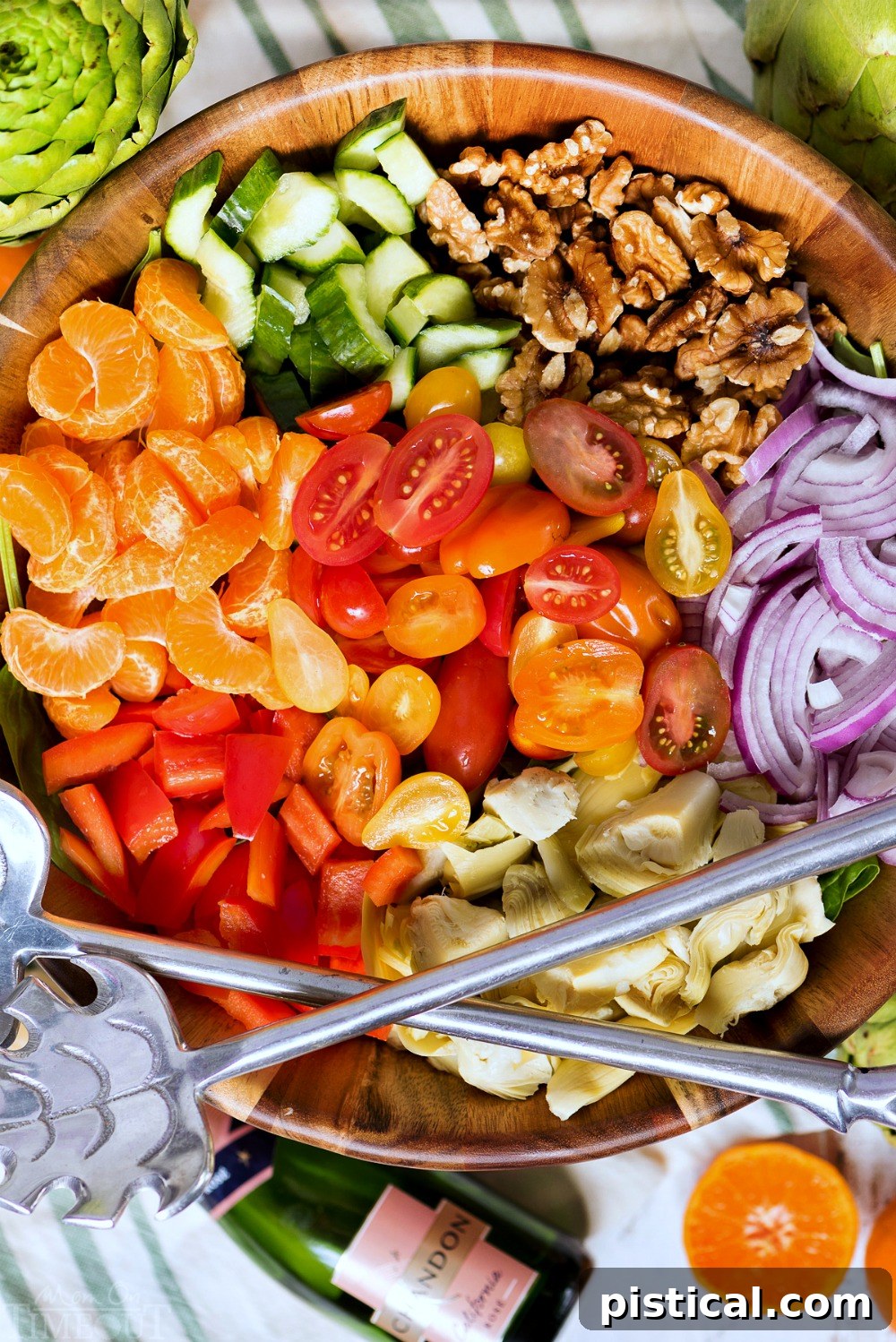 Ingredients for the Best Artichoke Pasta Salad: Fresh, Colorful, and Delicious. All the fresh ingredients for Perfect Pasta Salad laid out on a table, including pasta, spinach, mandarins, artichokes, and various vegetables, ready for preparation.