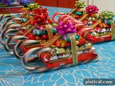 sleighs done Adorable candy sleighs made with small candy bars and candy canes, featuring a festive bow and decorative elements, perfect as party favors or small gifts.