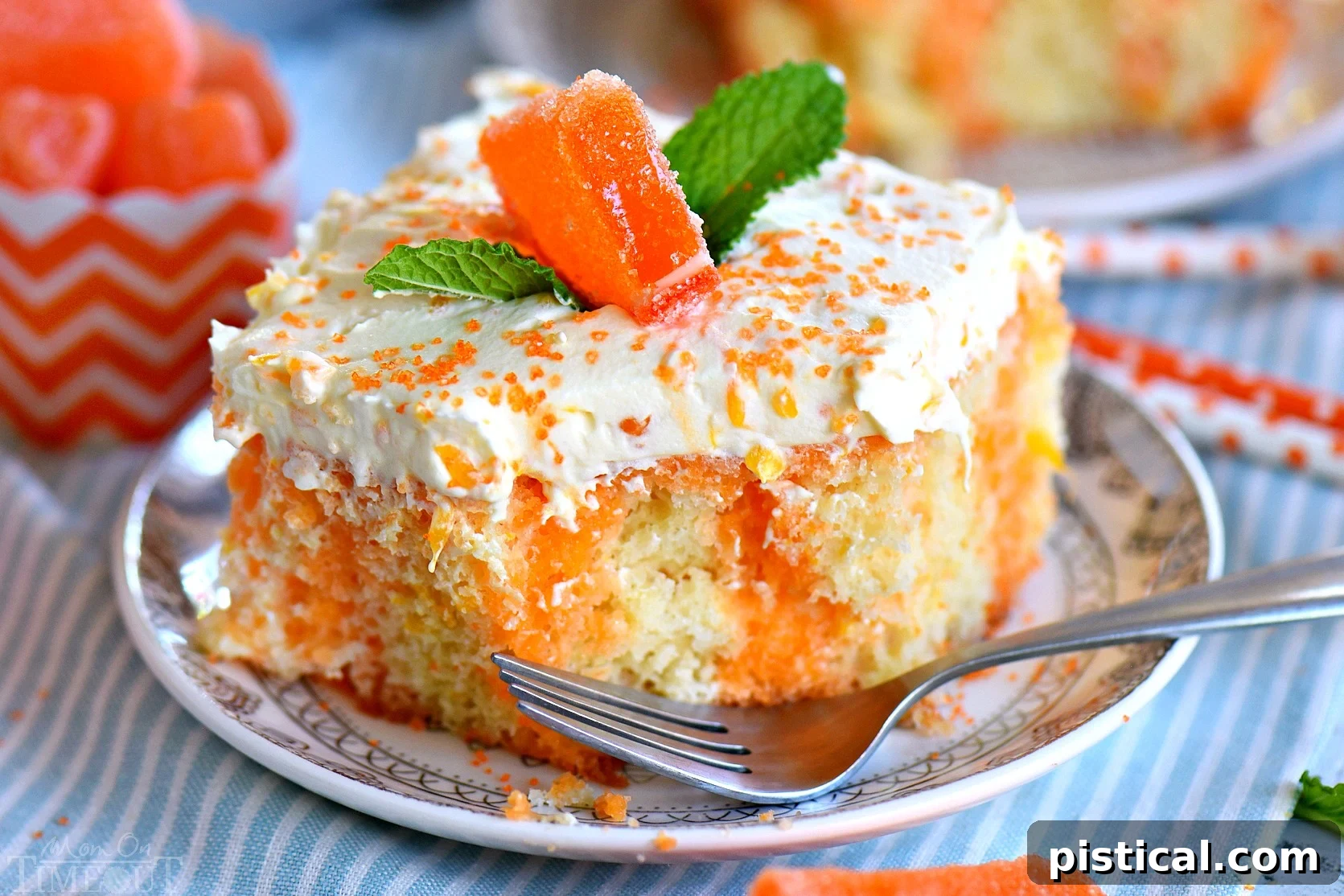 A square slice of Orange Creamsicle Poke Cake on a small white plate, with a bite taken out, revealing the moist interior and Jell-O streaks.
