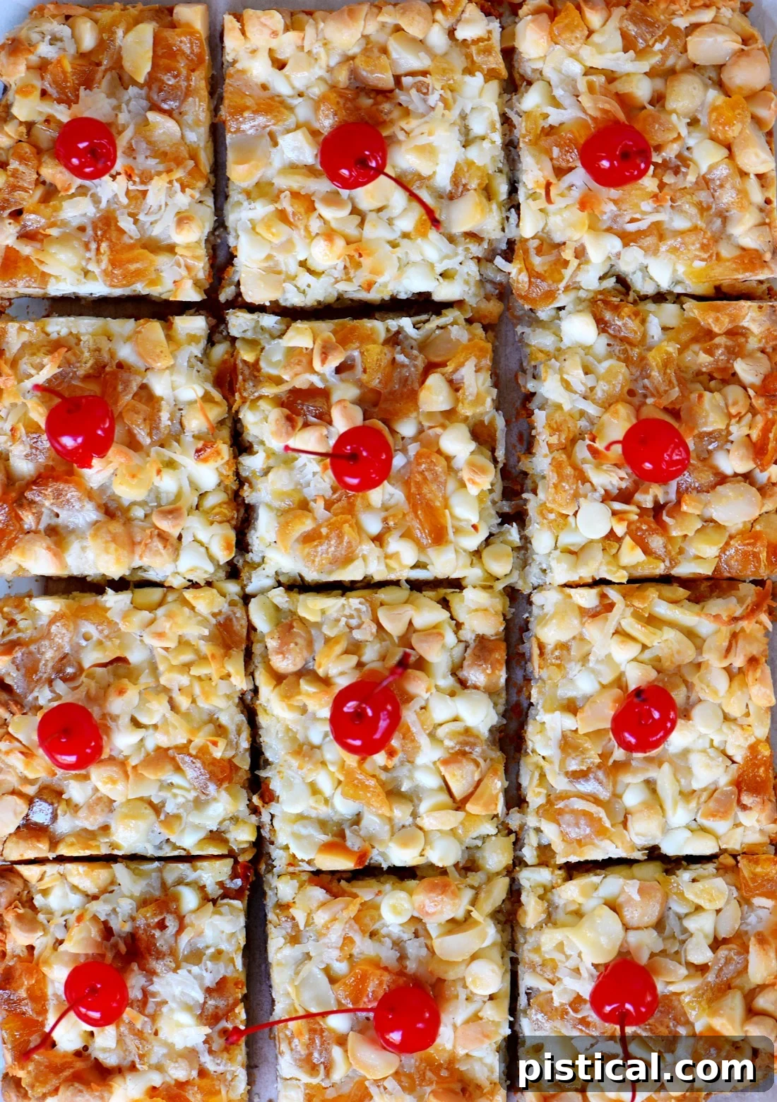 A serving of Piña Colada Magic Bars topped with a maraschino cherry, ready to be enjoyed as a delightful tropical dessert.