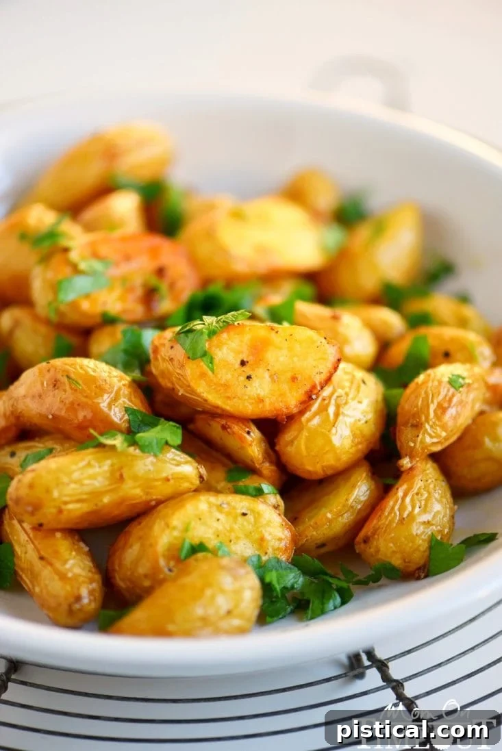 Oven-roasted potatoes with garlic and herbs spread evenly on a baking sheet, ready for the oven